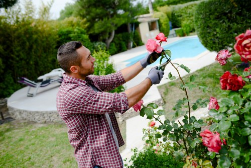 Garden maintenance worker following safe working practices